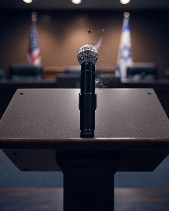 Un micrófono en un podio con una bala en el aire, acercándose a él. Dos banderas, la bandera estadounidense y la bandera israelí, son visibles en el fondo.