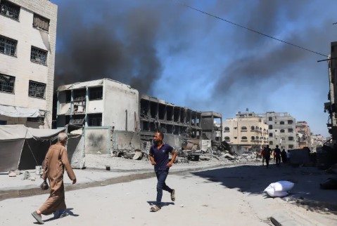 Qatar_Tribune's tweet image. Smoke billows from a forcibly evacuated #UNRWA school following #Israeli_air_strikes at Shati refugee camp, in #GazaCity. Israeli air strikes targeted two UN schools sheltering displaced Palestinians in Gaza City. At least 23 people have been killed. (Agencies)