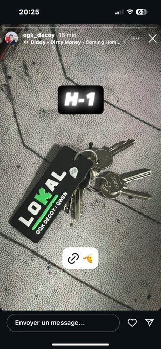 Keys attached to a keychain with a black tag displaying "LOKAL" in white text and green accents. A digital overlay shows "H-1" in white text on a black rectangular background. An Instagram watermark is visible in the top-right corner.