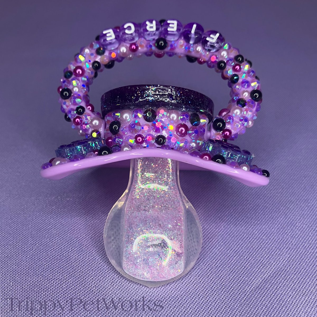 TrippyPetWorks's tweet photo. Clawdeen’s pacifier features a Completely Handmade resin centerpiece and dangle charm! Resin paw charms &amp; A unique black and purple Rhinestone/ faux pearl design! A purple Glitter filled I-spy nipple with purple paws &amp; Purple Hearts. Always durable for worry-Free Use!˚𝜗𝜚˚⋆ https://t.co/YZfRYOa3Cw