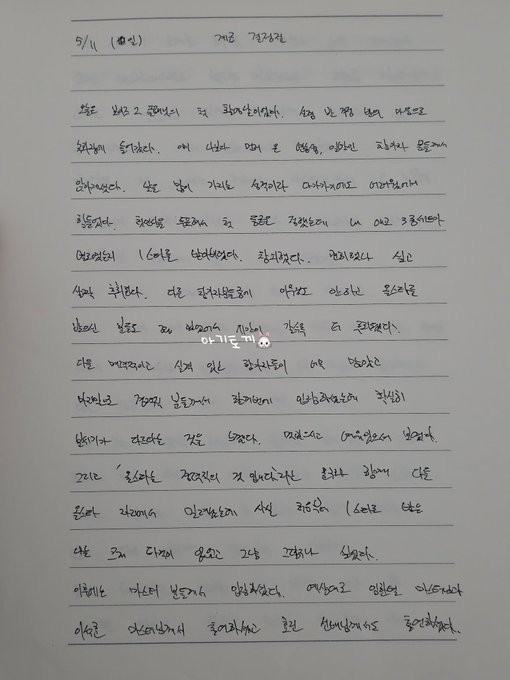 Handwritten text in Korean on lined paper, detailing a diary entry by Kim Geonwoo. The text is written in black ink, filling multiple lines with a mix of cursive and print styles. A watermark from X is visible at the bottom.