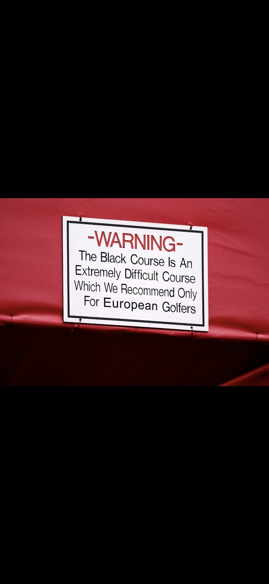 A red background with a white rectangular warning label. The label has black text reading "-WARNING- The Black Course is An Extremely Difficult Course Which We Recommend Only For European Golfers."