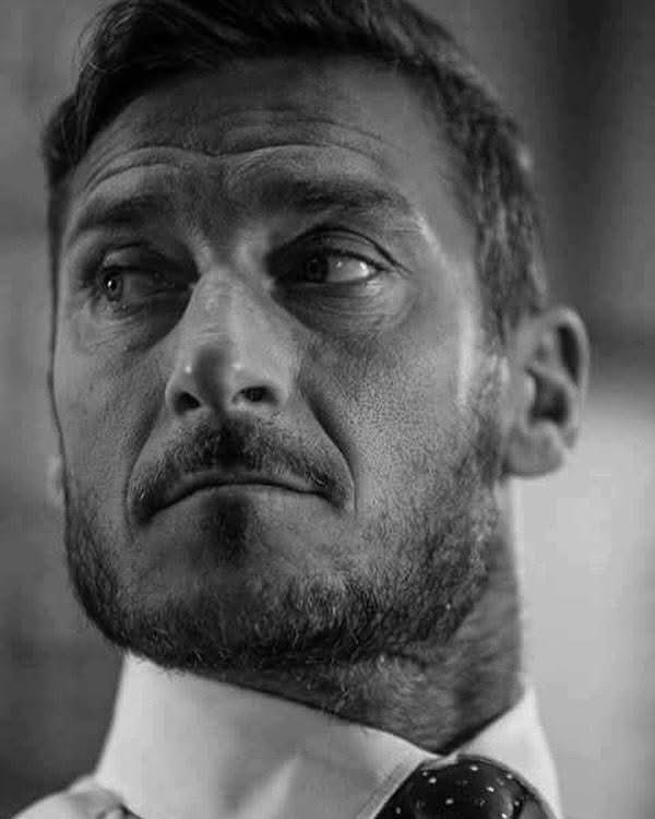 calciolog_tr's tweet photo. “Benim gençliğimle oğlumun dönemi arasındaki farkı çok net görüyorum. Bizim elimizde hiçbir şey yoktu ama sanki her şeye sahipmişiz gibi hissederdik.

Saatlerimizi saklambaç oynayarak, bir langırt maçına sevinçle coşarak ya da mahalledeki barın flipperinde rekorlar kırmaya çalışarak geçirirdik. Cebimde bozukluk arar, 500 lirelik bir dondurma almayı umardım ama param sadece en ucuzlarına yeterdi: Lemonissimo, Magic Cola ya da Arcobaleno… Yarı fiyatına satılan şeylerdi onlar.

Oğluma büyüdüğüm değerleri aşılamaya çalışıyorum ve ona şunu anlatıyorum: Kötü biri olmak çok kolaydır. Dilerim hatalar yapar ama aklını kullanarak yapar; çünkü bir genç düştüğünde, sonrasında sadece yarayı kapatmaya çalışabilirsin. Elbette çok iyi çocuklar var, hem de pek çok, ama bugünün 14 yaşındakileriyle kıyasladığında biz gerçekten saf, tam anlamıyla çocuktuk. Eve dudaktan minicik bir öpücükle ya da yanağa kondurulmuş küçücük bir buselerle dönerdik ve günlerce hayaller kurardık. Bugünse 12 yaşındakilerin farkındalık düzeyini gördüğünde insanın saçı başı diken diken oluyor, korkuyor ve haç çıkarmak istiyor. Onlar bambaşka düşünüyorlar ve bizim gençliğimizle kıyaslandığında yollarını kaybetmeleri çok daha kolay.” - Totti