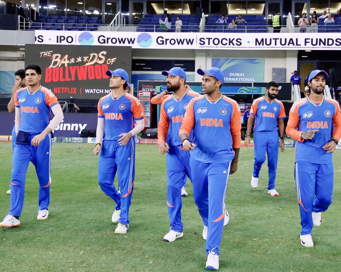 Indian cricket players wearing blue and orange uniforms with 