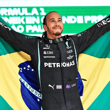 Lewis Hamilton wearing a black racing suit with logos including Mercedes, Petronas, and UBS. His arms are raised, and he is draped with a Brazilian flag. A second image shows the flag of Israel.