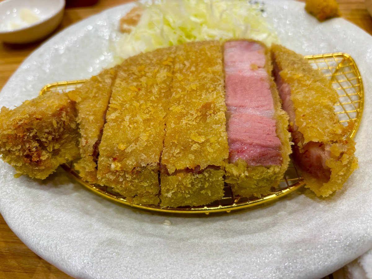 夕食で、平針で厚切りトンカツを食す。
低温で加熱したのだろう。
カツの断面はローストビーフの様に赤く、一見すると生の様だ。
身は厚いがとても柔らかく、口に含むと旨みが広がる。
衣は薄く、箸で掴むと崩れてしまい、低温加熱の弊害か油が抜け切っておらず、少し残念。
高いけどまあ美味かった。