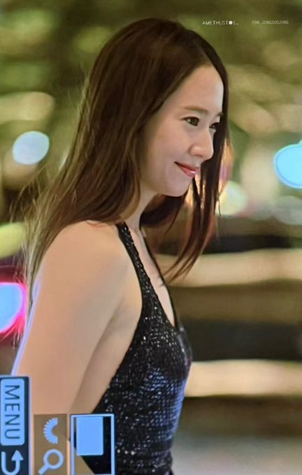 Krystal Jung wearing a sleeveless, black sequined dress with a side cutout, holding a small clutch. Her long, straight brown hair flows over her shoulders. The background features blurred lights and a person in a dark suit, suggesting an evening event. Watermarks from X are visible on the images.