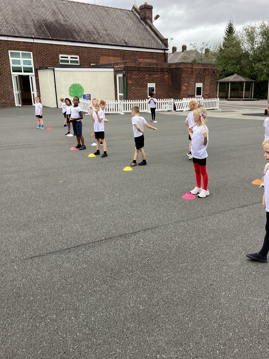 The children in 2M are developing the skill of sending and receiving the ball. They are rolling the ball with precision, ensuring that their partner is ready to receive it.