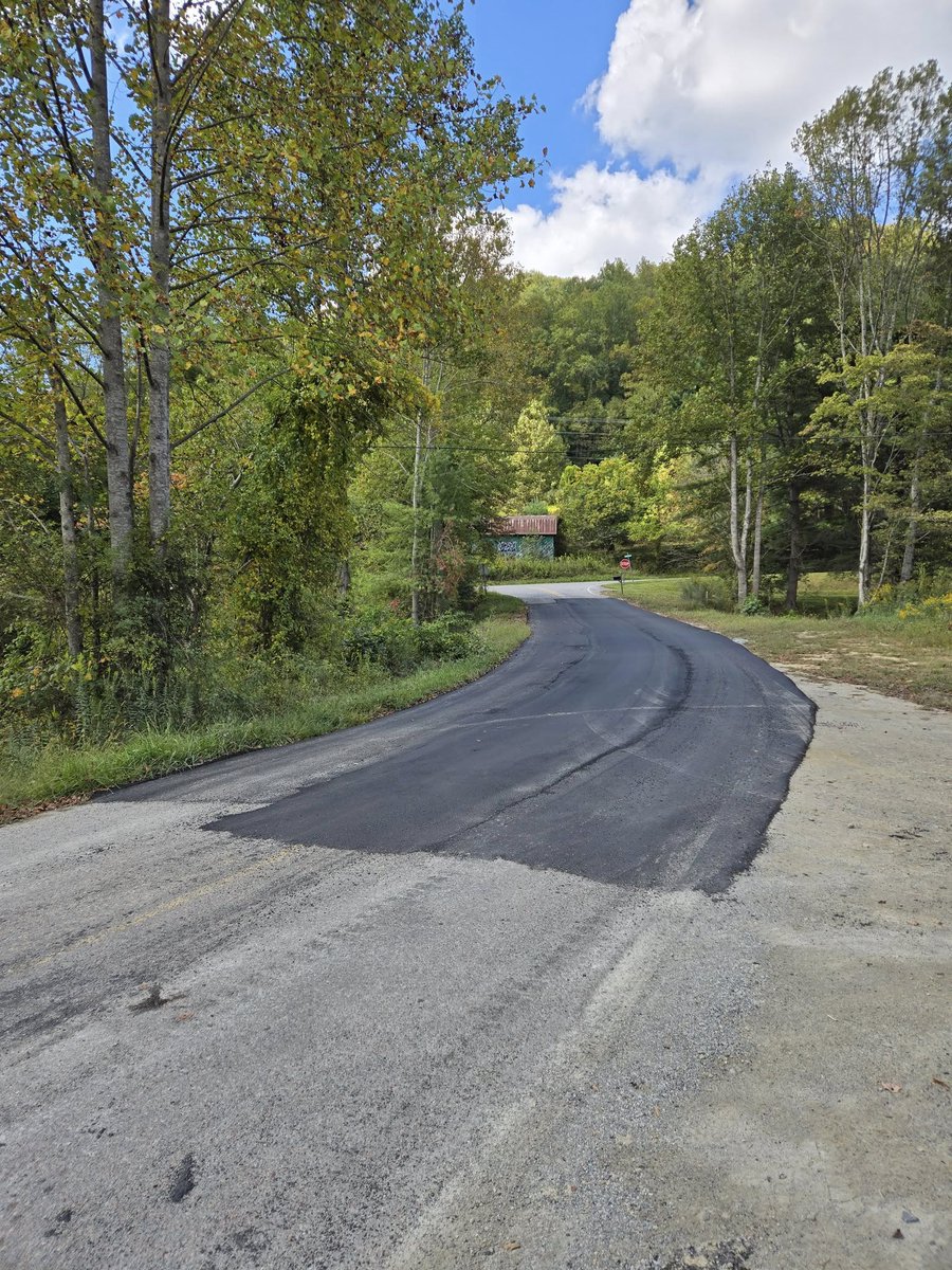 The road, literally, to rebuilding after Helene continues. First photo is from Baird's Creek Road the day after the storm. Second photo is today after some spot paving was finally able to take place over the gravel repair that has been in place for months. Photos: Paul Ford.