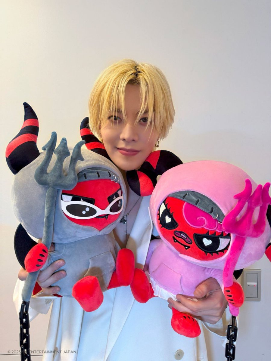 NCT 127's YUTA poses with the large plushie versions of his kids