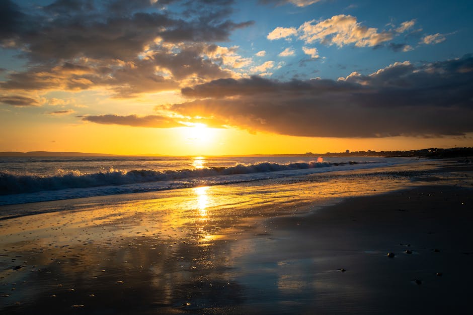 Stunning sunset over Bournemouth Beach with golden reflections on the sea and sand.