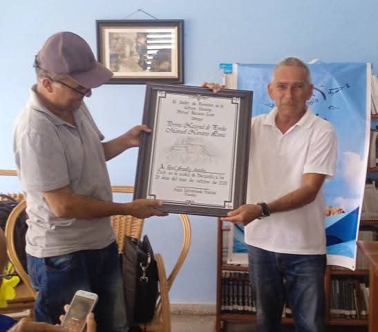 CNCTVGranma's tweet image. Ronel González Sánchez y Reynaldo Zaldivar, ganadores del premio Nacional de poesía "Manuel Navarro Luna" que participan en la 35 edición del festival Al Sur está la Poesía, fueron reconocidos durante una de las jornadas de este evento que se celebra cada año en #Pilón.