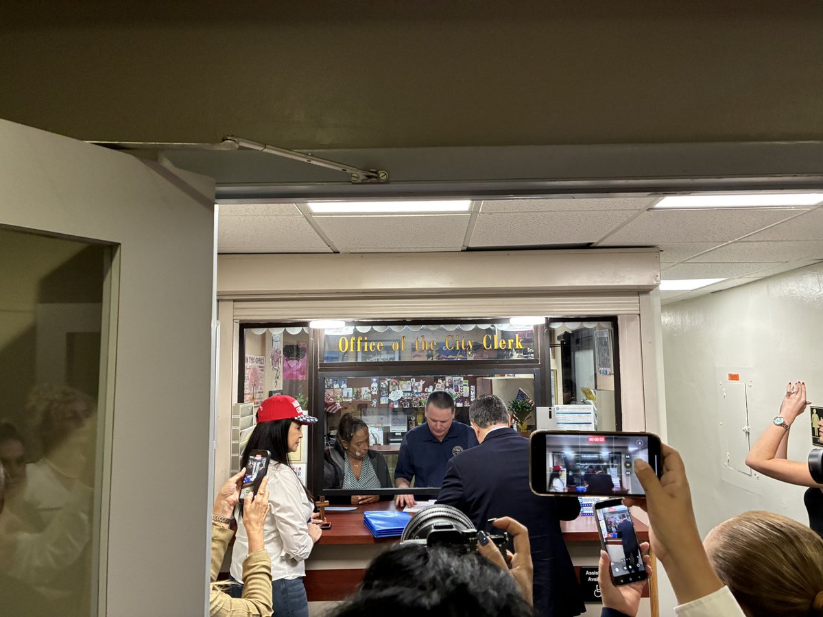 A crowd surrounds Joe Carollo as he files his candidate paperwork for Miami mayor