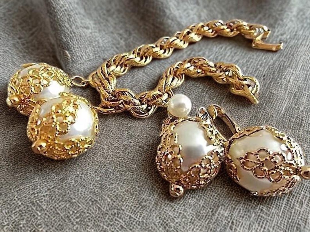 Vintage CELEBRITY Pearl Charm Bracelet-Earrings Set, Filigree Caps, Gold Plate by RenaissanceFair: 44.00 USD

A lovely vintage bracelet and earrings set by Celebrity in bright shiny gold-tone. Attached to the charm bracelet are two large faux pearls… dlvr.it/TNCD1l
