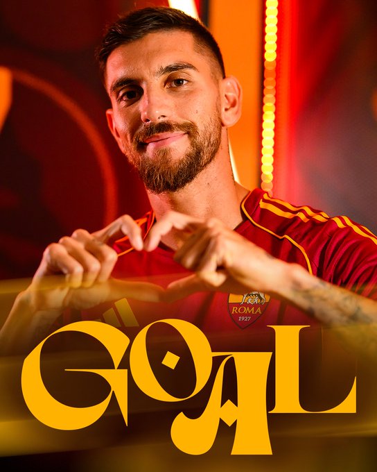 Lorenzo Pellegrini wearing a red AS Roma jersey with yellow stripes, forming a heart shape with his hands. The jersey displays the AS Roma logo. The word "GOAL" in large yellow letters is overlaid on the image.