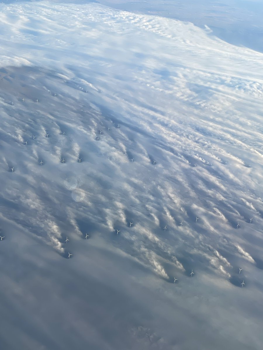 Took this photo flying in to Denver this morning. Low level fog allows you to see the wake generated by each windmill. Cool!