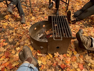 Grab your PSL, chunky scarf and come to MacGregor Point to see the autumn leaves.🍂 

Happy Autumn Equinox 🧡 

[image 1]: a campfire surrounded by orange leaves on the ground.