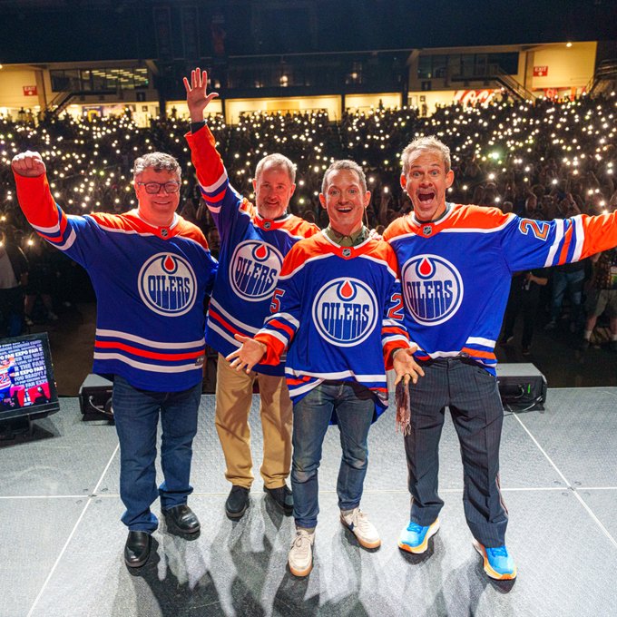 Sean Astin (Samwise Gamgee), Billy Boyd (Pippin Took), Elijah Wood (Frodo Baggins) and Dominic Monaghan (Merry Brandybuck) on stage wearing Oilers jerseys at Edmonton Expo. 