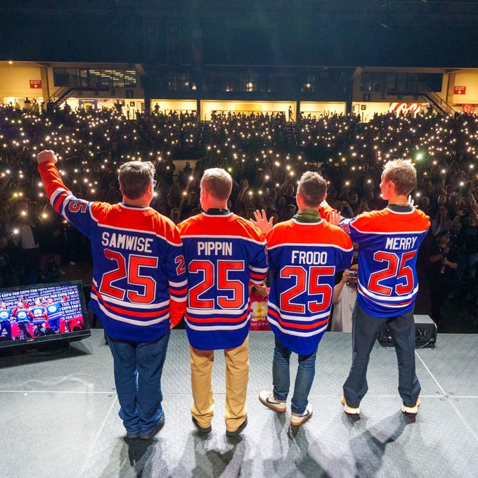 Sean Astin (Samwise Gamgee), Billy Boyd (Pippin Took), Elijah Wood (Frodo Baggins) and Dominic Monaghan (Merry Brandybuck) on stage wearing Oilers jerseys at Edmonton Expo. 