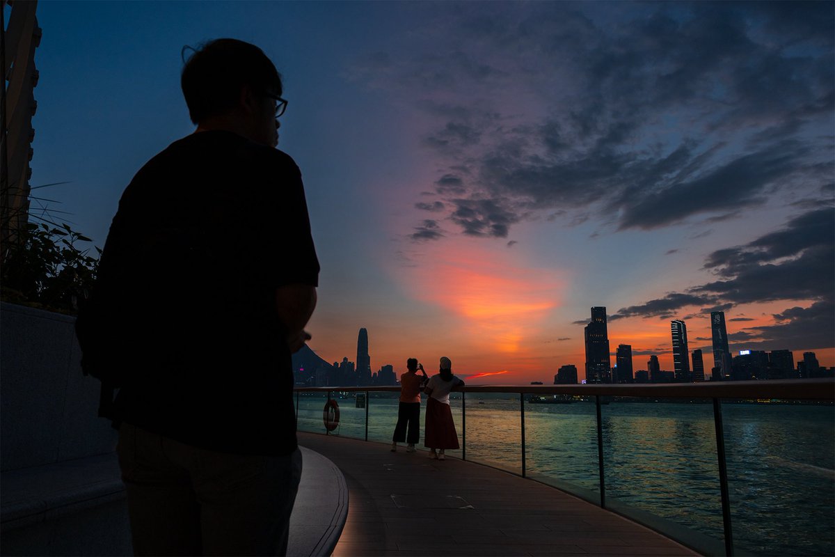 People watch the sunset at Victoria Harbour as Super Typhoon Ragasa moves towards Hong Kong