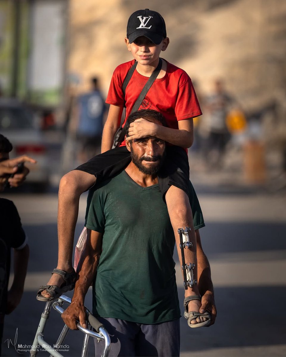🚨Heartbreaking: An exhausted father carries his injured son on his shoulders while fleeing from northern to southern Gaza, struggling through relentless Israeli bombardment.