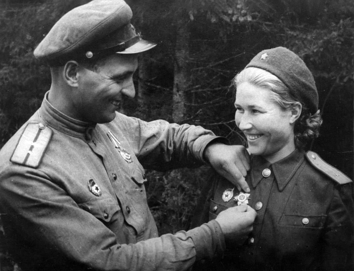 Aleksandra Boiko's husband Ivan pins the Order of the Patriotic War 1st class on her uniform during an awards ceremony, August 1944