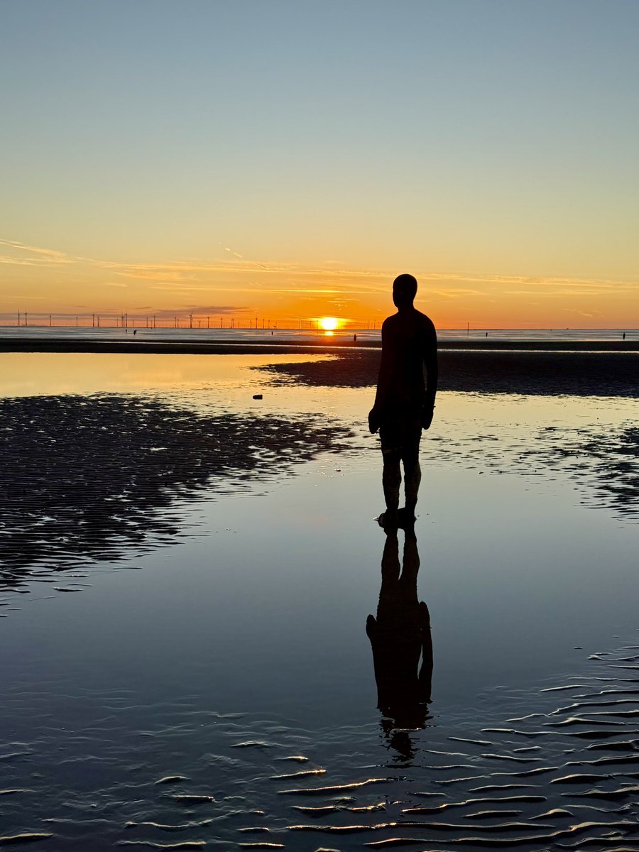 Pools of blue reflect the calm clear skies over Crosby beach last night as the setting sun painted the horizon with streaks of warm gold. 
<a href="/IronMenCrosby/">IronMenCrosby 🌤</a> #SeftonCoast