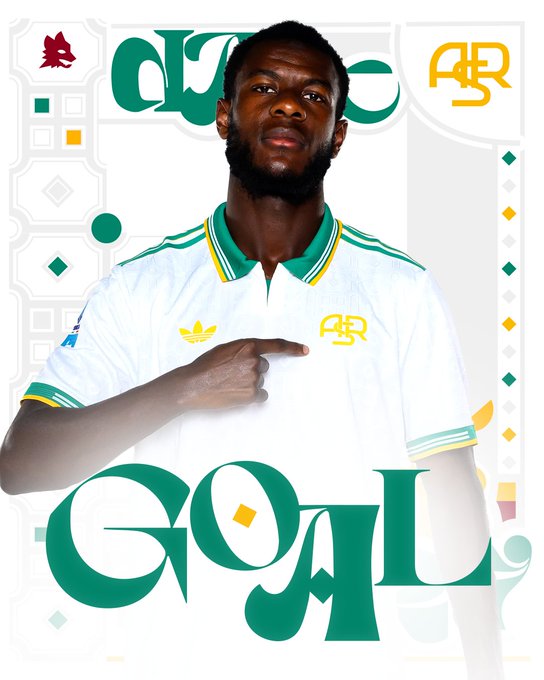 Evan Ndicka wearing a white AS Roma jersey with green and yellow trim, pointing at himself. The jersey has the AS Roma logo and an Adidas logo. Large green text reading "GOAL" is overlaid on the image.