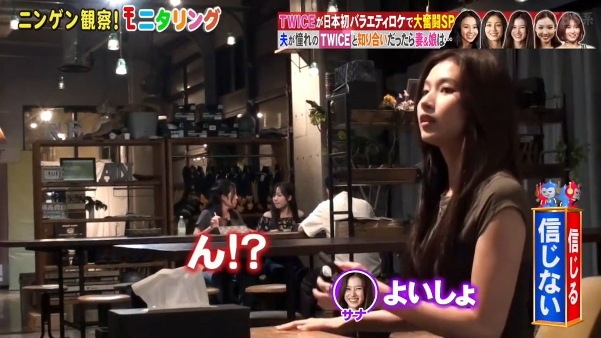 A scene from the Japanese variety show "ニンゲン観察！モニタリング" (Ningen Kansatsu! Monitoring) featuring TWICE member Sana interacting with a mother and daughter duo at a café, with the "ん!?" reaction graphic suggesting a prank moment, alongside show graphics identifying her as "サナ" (Sana) and noting the pair are J-ONCEs who know each other's ages.