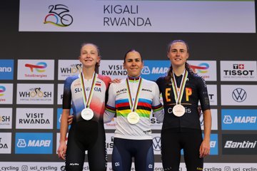 Three women standing on a podium wearing cycling uniforms. Célia Gery in the center wears a rainbow-striped jersey and gold medal, Viktória Chladoňová on the left wears a silver medal, and Paula Blasi on the right wears a bronze medal. A backdrop displays "KIGALI RWANDA" and logos like UCI, Tissot, and Visit Rwanda. A second image shows Célia Gery raising her arms in victory, wearing a cycling uniform with a gold medal. A third image depicts a group of cyclists and coaches on a podium, with Célia Gery in the center holding a French flag, all wearing cycling attire.