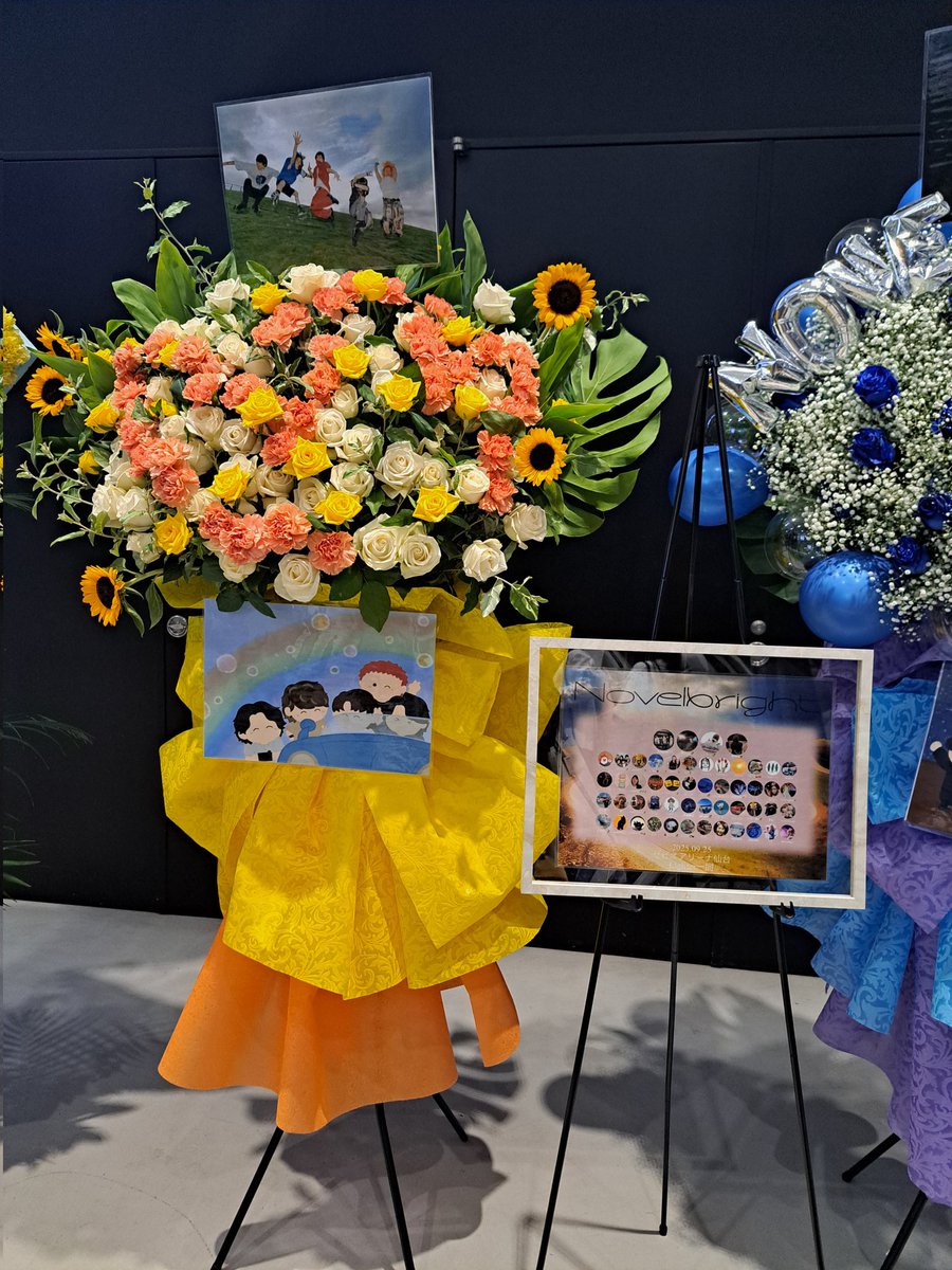 s_ayakoo's tweet photo. 仙台振替公演！フラスタ企画にご協力いただいた52名の皆さんありがとぉございました😌✨
初めてのことで右も左も分からない中、贈りたいと言う想いに賛同して協力してくれた皆さんに感謝します🙏✨
そして一緒に意見を出し合ってくれたイツメンに感謝します✨
とっても素敵なフラスタを贈ることが出来たのは皆さんのご協力があったからこその事です😳
1人では絶対に出来なかった。
そしてもう1基あれちゃんの協力もあって同じようなフラスタにならないようにとどんなフラスタを贈るかを情報共有し合って出せたこともとても感謝します🥰
当日にイレギュラーなことも起きましたが、会場に居たあれちゃんが対応してくれて本当に助かりました！最後会うことが出来なかったのでこの場をお借りしてお礼申し上げます✨
この想いの詰まったフラスタ3基かメンバー及びスタッフさんに届いてますように✨
 #novelbright_アリーナツアー  #仙台振替公演