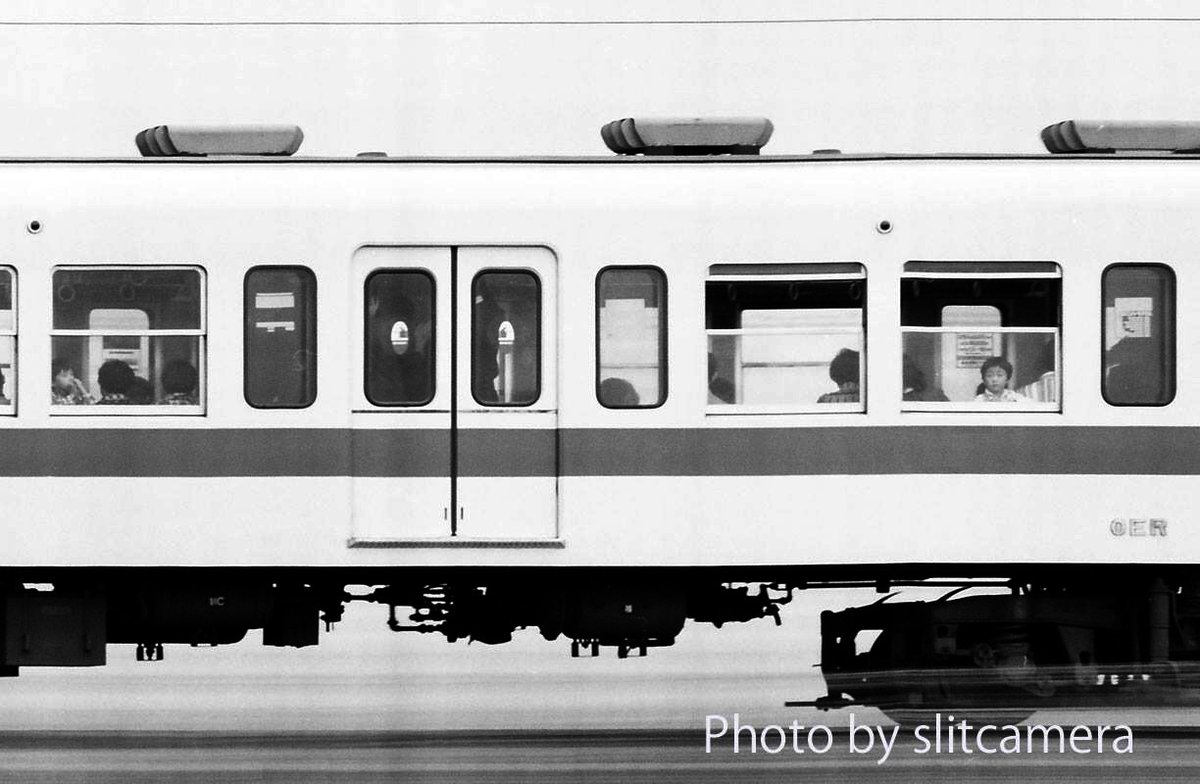 思い出のスリットショット(続)：車窓の子供たち

列車の窓際で外を眺める子供たちの光景を車内から撮影した写真はときどき見かけますが、高速で走る列車で車窓から外を眺める子供たちを外側から列車ごと写した写真は殆どお目にかかれません。