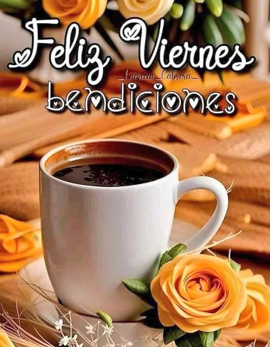 A white ceramic coffee cup filled with dark coffee, placed on a saucer. Yellow roses and green leaves are arranged around the cup. The background includes a wooden surface and orange flowers.