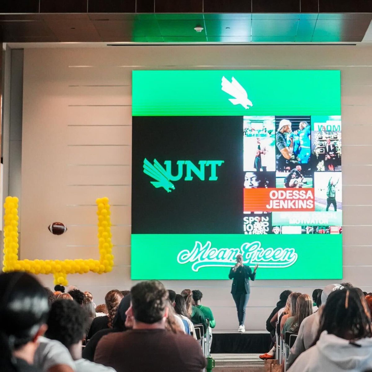 UNT_ELEVATE's tweet photo. 𝙇𝙚𝙜𝙖𝙘𝙮: 𝙞𝙢𝙥𝙖𝙘𝙩 𝙩𝙝𝙖𝙩 𝙤𝙪𝙩𝙡𝙖𝙨𝙩𝙨 𝙩𝙝𝙚 𝙨𝙘𝙤𝙧𝙚𝙗𝙤𝙖𝙧𝙙

Shoutout to Odessa Jenkins for challenging and empowering Mean Green student-athletes to identify their PASSIONS, use their PLATFORM, and put up reps in building PERSEVERANCE! 

#ELEVATE x #GMG 🟢🦅 https://t.co/6evvRRFtd7