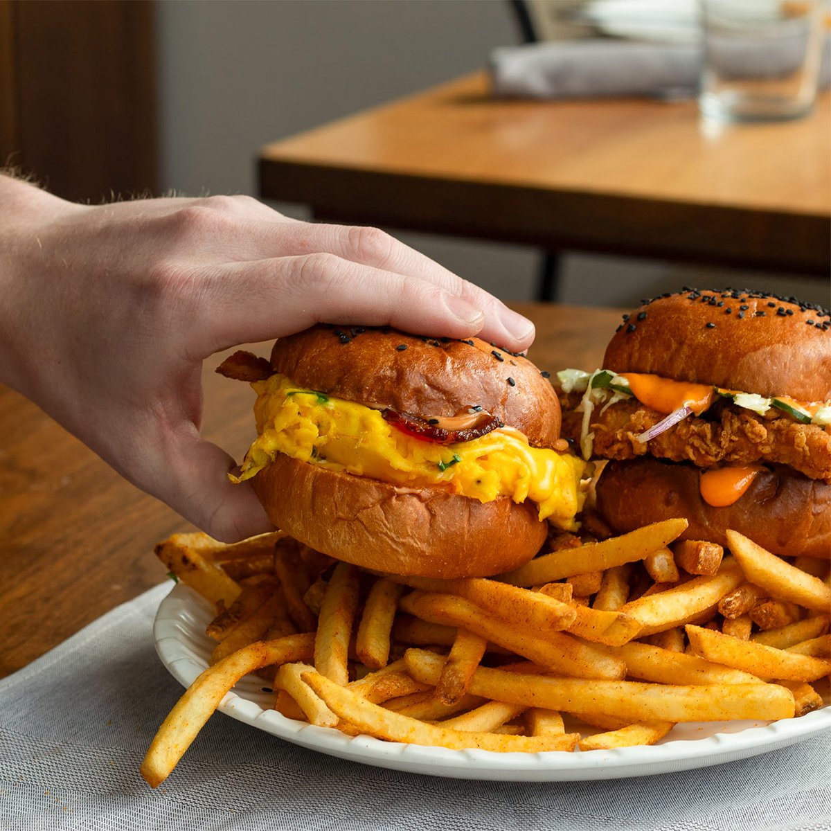 Brunch is calling… and it’s S"eggs"Y. Scrambled egg, bacon, fancy “cheez,” scallion, and sexy sauce all on a sesame bun, served with fries. Bring the crew and dig in. 🍳🍔🍟
