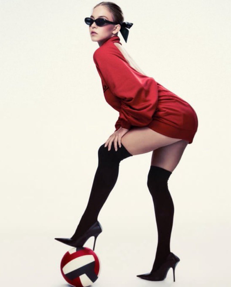 Game, set, slay. Elevating the game, one stiletto at a time. Lily turns a volleyball moment into high fashion, rocking a bold red mini dress with an open back, thigh-high black stockings, sleek stilettos, and sharp black shades. Pure statement energy.
