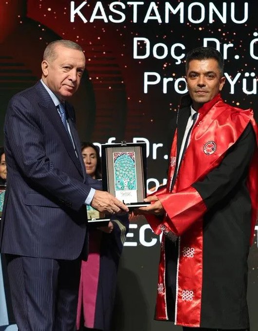 First image shows two men in formal attire on stage with a red backdrop displaying Kastamonu University text, one older man in a dark suit with blue tie identified as Recep Tayyip Erdoğan shaking hands and presenting a framed award featuring intricate blue tilework to a younger man in a white robe with red accents. Second image depicts the same individuals with Erdoğan in suit handing the award to a man in a red robe over black attire, surrounded by blurred audience members including women in colorful dresses. Third image is a close-up of an ornate certificate with gold and brown borders, YÖK 2025 Superior Achievements text, mentioning Kastamonu University award to Prof. Dr. Ahmet Hamdi Topal and Assoc. Prof. Dr. Önder Tor for international cooperation.