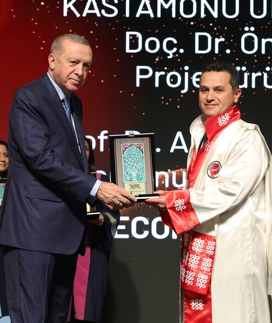 First image shows two men in formal attire on stage with a red backdrop displaying Kastamonu University text, one older man in a dark suit with blue tie identified as Recep Tayyip Erdoğan shaking hands and presenting a framed award featuring intricate blue tilework to a younger man in a white robe with red accents. Second image depicts the same individuals with Erdoğan in suit handing the award to a man in a red robe over black attire, surrounded by blurred audience members including women in colorful dresses. Third image is a close-up of an ornate certificate with gold and brown borders, YÖK 2025 Superior Achievements text, mentioning Kastamonu University award to Prof. Dr. Ahmet Hamdi Topal and Assoc. Prof. Dr. Önder Tor for international cooperation.