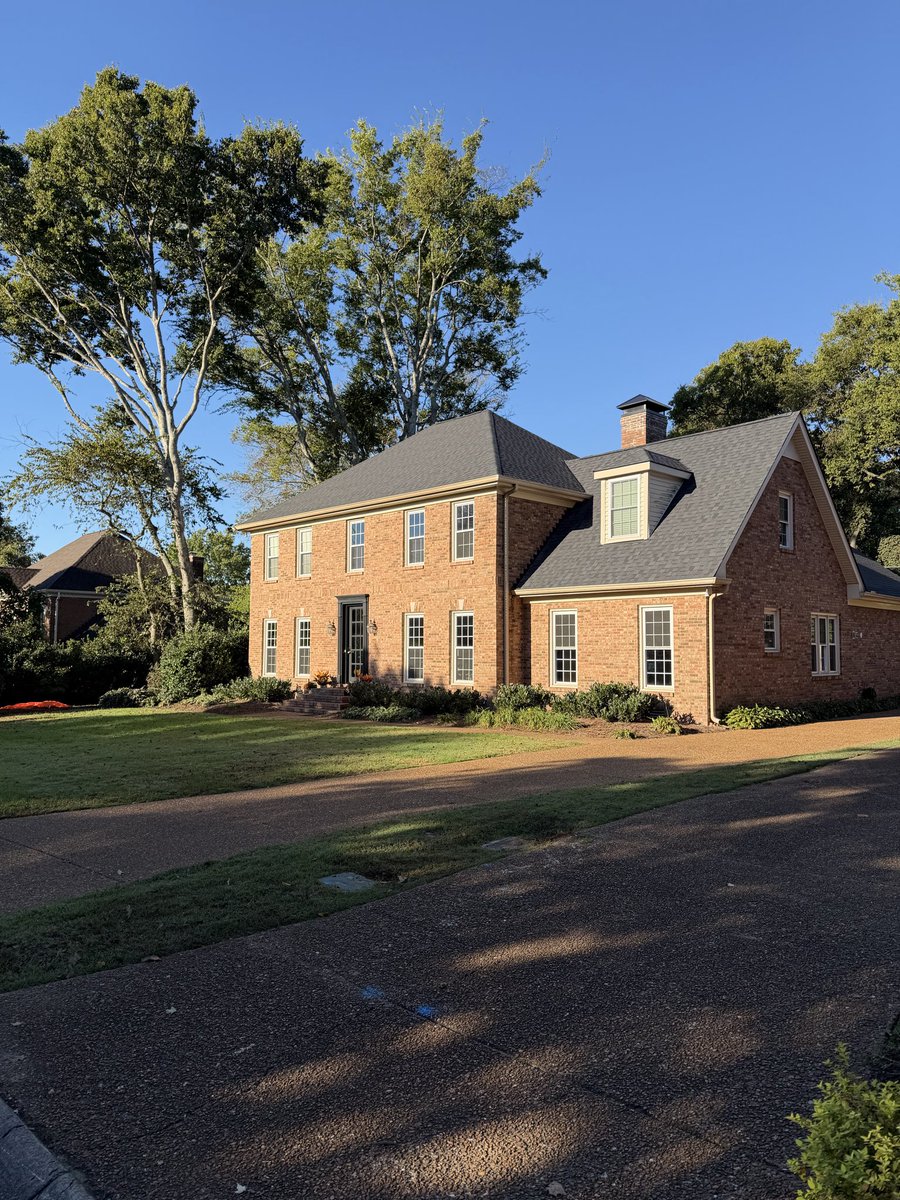 has a strong colonial-esque vibe—reminiscent of Georgian or Federal Revival architecture—with its symmetrical facade and brick construction
