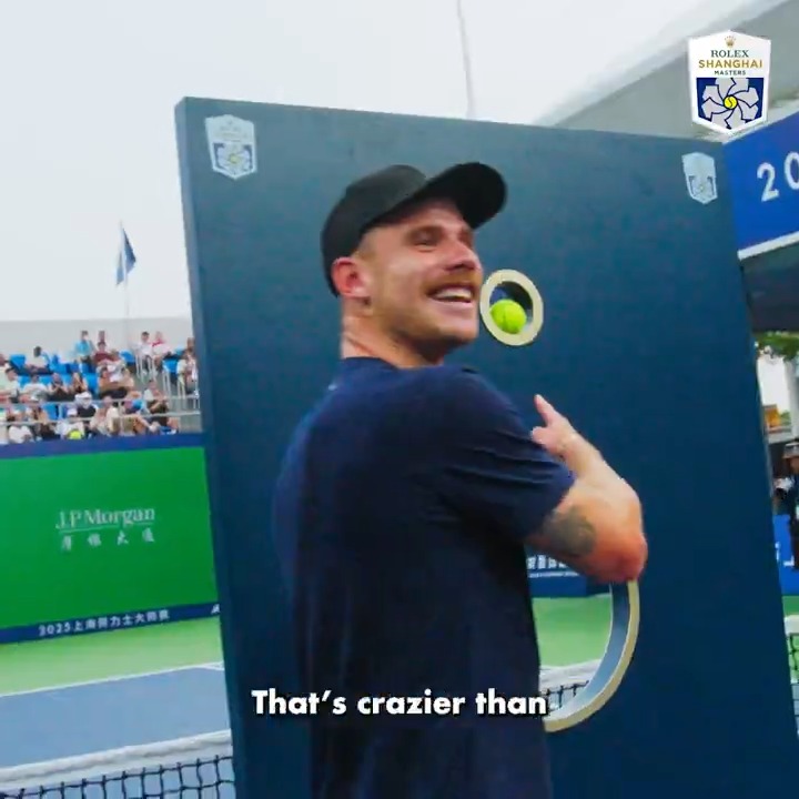 A man in a black cap and t-shirt smiles while standing near a target at the Rolex Shanghai Masters, with text overlay reading "That's crazier than".