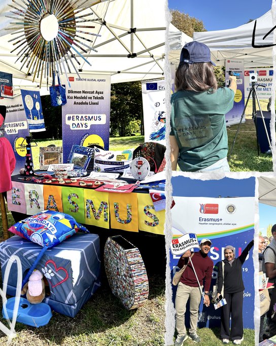 Outdoor event setup in a park with green grass and trees under blue sky. White tents and inflatable structures with Erasmus+ Days banners in blue and yellow. Turkish flag waving on left. People in casual clothes including hats and striped shirts gathered around barriers and tables with promotional items like pillows and documents. Colorful displays with EU flags and rainbow elements on tables. Photo booth area with props like signs and flowers in pink and purple. Additional tent with red tablecloth and blue materials.