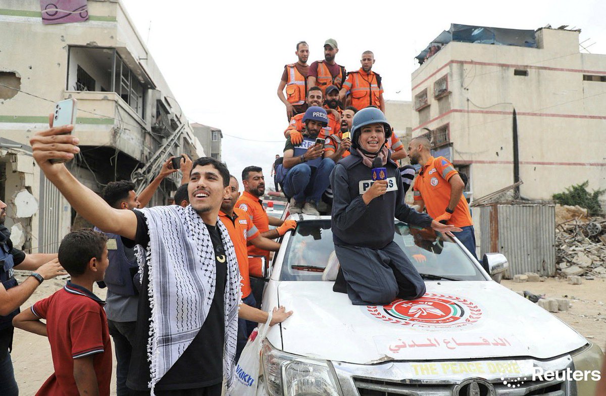 idreesali114's tweet image. Al Jazeera reporter Nour Abu Rokba works, as Palestinian emergency personnel celebrate, after U.S. President Donald Trump announced that Israel and Hamas agreed on the first phase of a Gaza ceasefire, in Gaza City, October 9, 2025. REUTERS/Ebrahim Hajjaj
