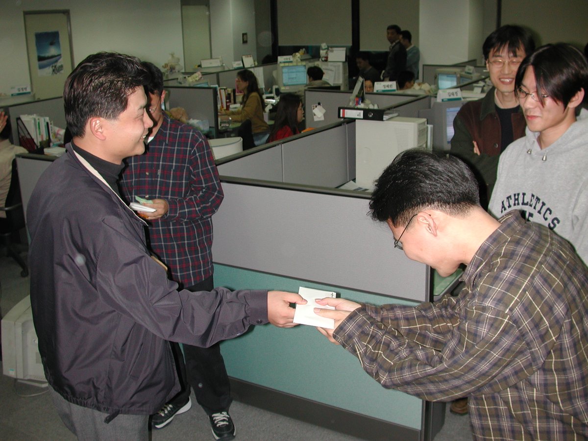 lqez's tweet image. 내가 찍은 가장 오래된 회사 사진 중 하나. 2001년 11월. 김범수 대표가 연말 보너스를 금일봉으로 직원들에게 주고 있는 것으로 보인다. 뒤에 이해진 대표의 모습도 보인다.