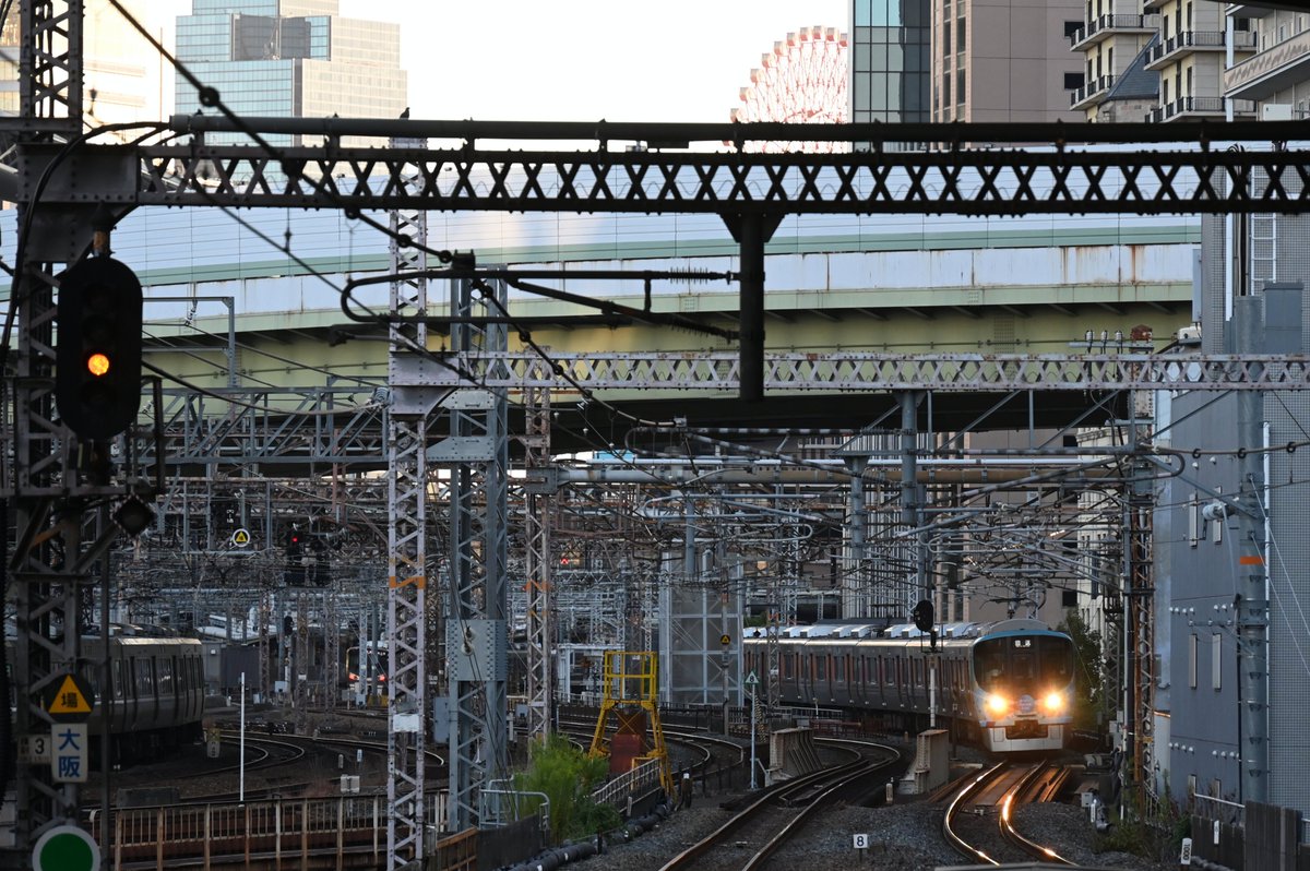 Mizunya333's tweet photo. エキスポライナーが平日ダイヤで走るのも、今日が最後でした。最後の朝の回送は、観覧車をチラ見できる都心の駅で見送りました。（2025.10.10撮影・大阪環状線 大阪～福島） #大阪環状線 #323系 #Parede Train #LS12 https://t.co/gbmwJngZjJ