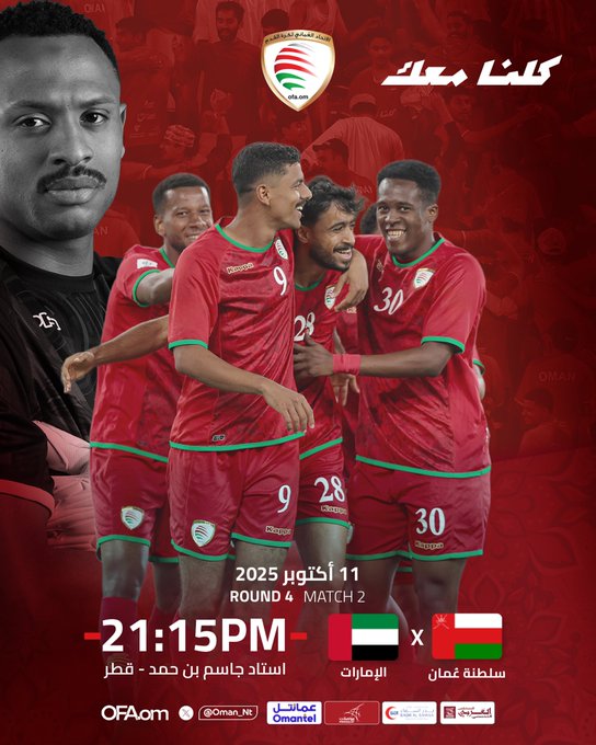 Group of Omani football players in red jerseys with green accents and numbers like 9, 28, 30, standing together arms around shoulders in celebration, one player in foreground facing viewer, Omani flag emblem on jerseys, text overlays for ROUND 2 PLAY 2, 21:15 PM, UAE vs OMAN, sponsor logos including OFA and others at bottom.