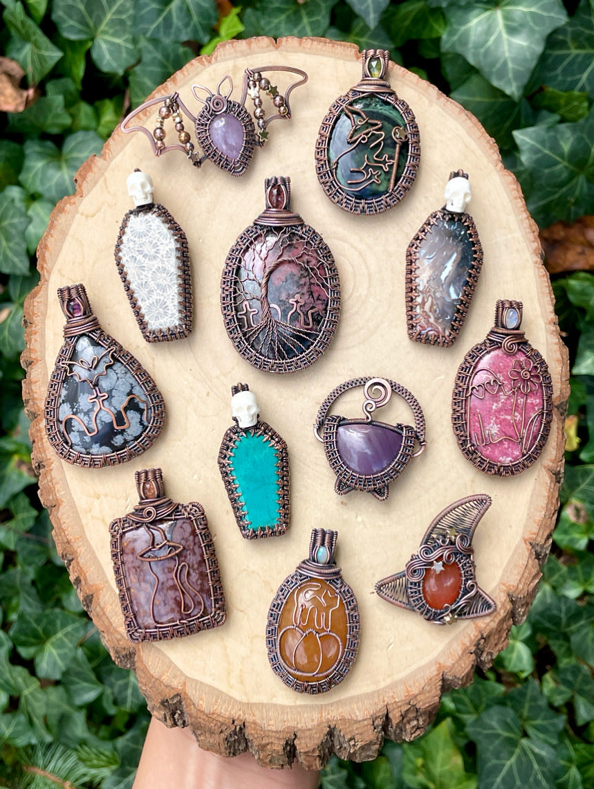 WickedWireCraft's tweet photo. Here’s a family photo of today’s collection dropping at 7pm EST! 🦇🎃👻 This week, I made 12 new pendants each crafted with so much love, magic, &amp; whimsy. 🥰 I’m so excited to get to share them all with you! Which one is your favorite? https://t.co/qY8kVRmP0f