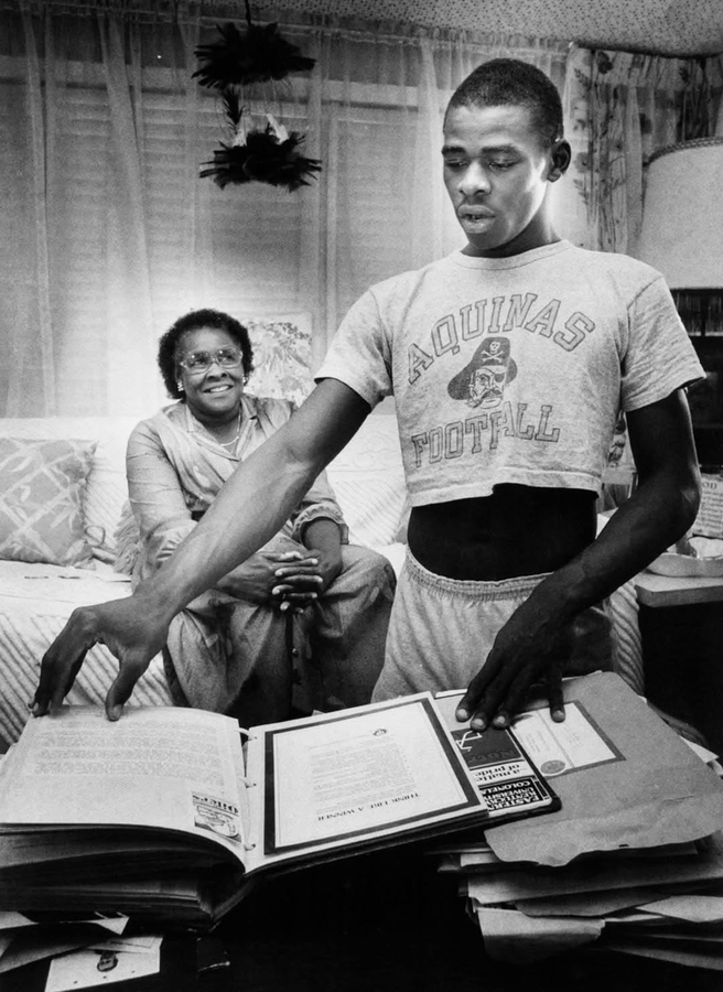 Michael Irvin looks through a pile of college scholarship offers with his mother at their Fort Lauderdale home.