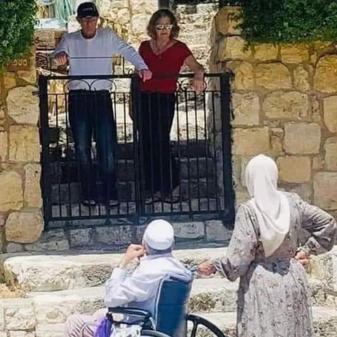 GSMFlotilla's tweet image. An old Palestinian couple standing in front of a house they built and owned now occupied by Jews who came from the United States.