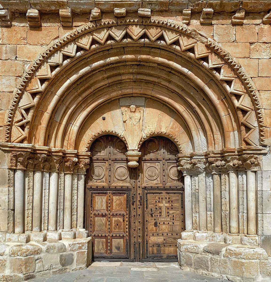 Tendría cientos de iglesias dedicadas a San Miguel Arcángel para elegir hoy, día de su fiesta, pero una de las que me apetece traer sí o sí es la de Caltojar (Soria), con esta portada dotada de su inconfundible pinjante y la efigie del Arcángel titular presidiendo el tímpano
