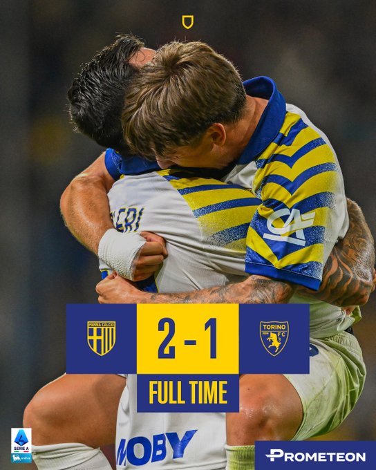 Two soccer players in jerseys hugging on a field. One wears a white jersey with black text "BERI" on the back, the other a yellow and blue striped jersey with a logo. A score overlay shows 2-1 with "FULL TIME" in yellow, and team badges for Parma and Torino.